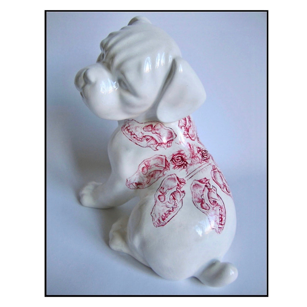 China puppy figurine with a red Biro drawing of a dog skulls pattern